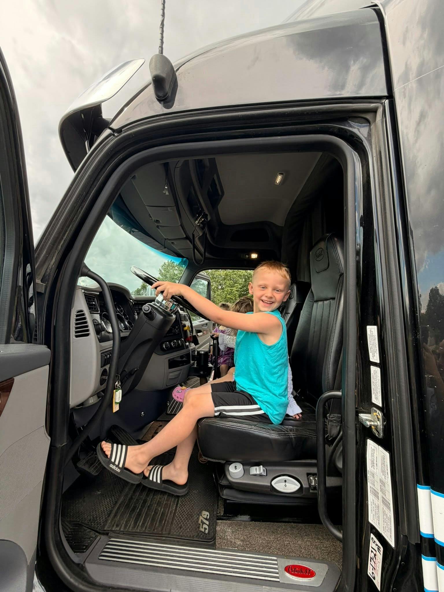 Child sitting in the driver seat of a truck