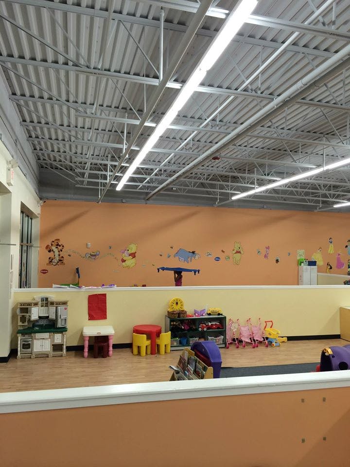 Playroom with toys, small chairs, and character decals on the wall