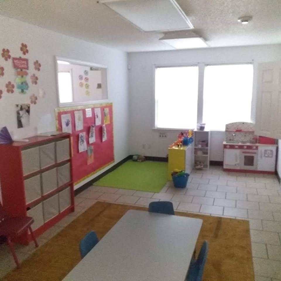 Classroom with tables, chairs, and play kitchen