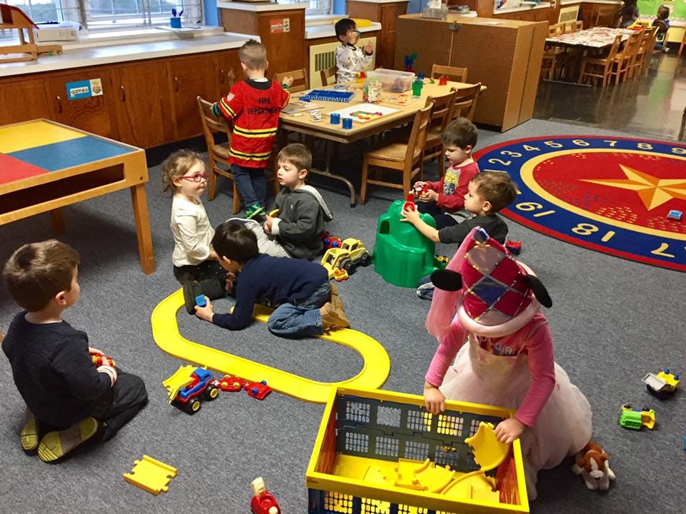 Children playing with toys on a classroom floor