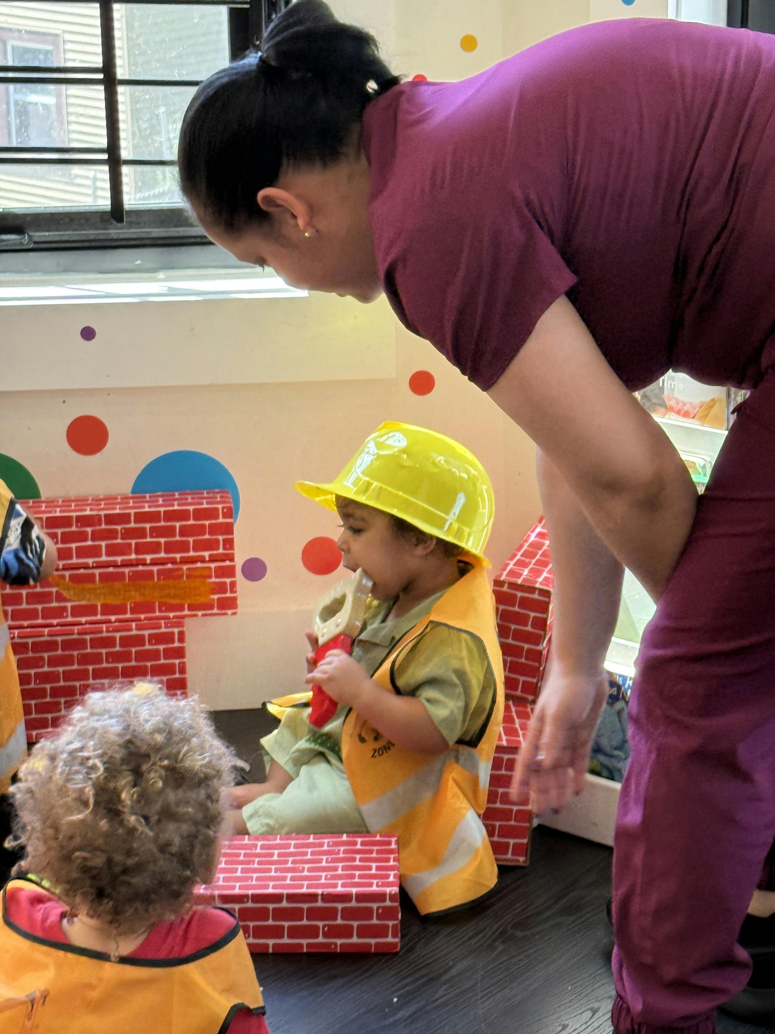 A person watching children play with construction toys in a classroom