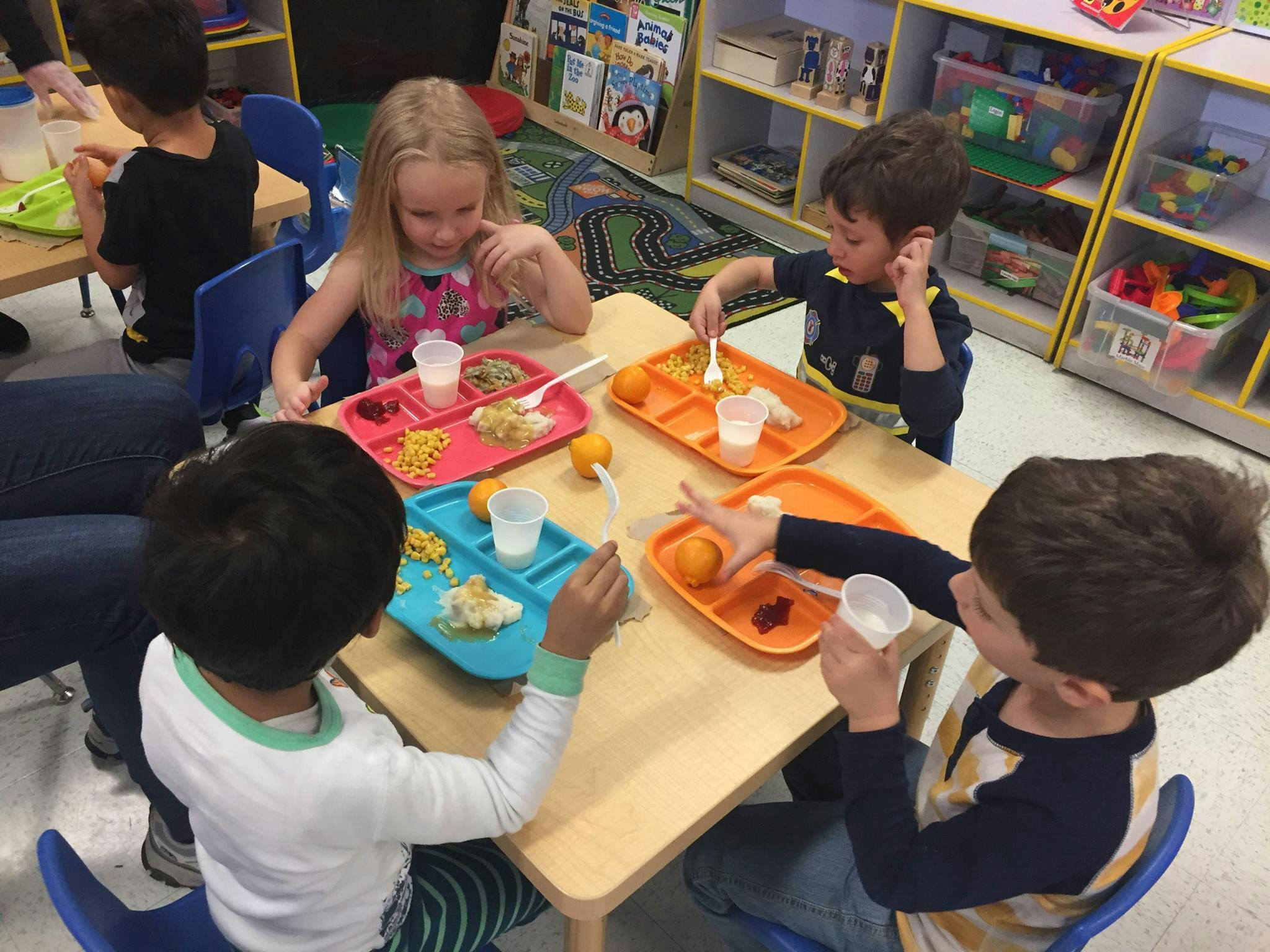 Children eating at a table in a classroom