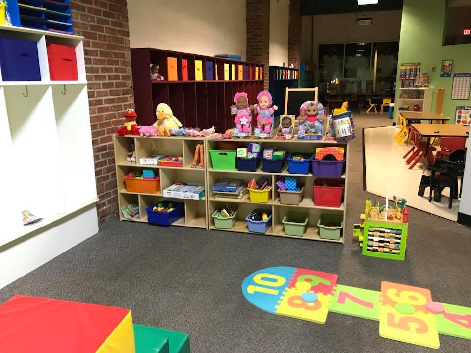 Playroom with shelves of toys and colorful floor mats