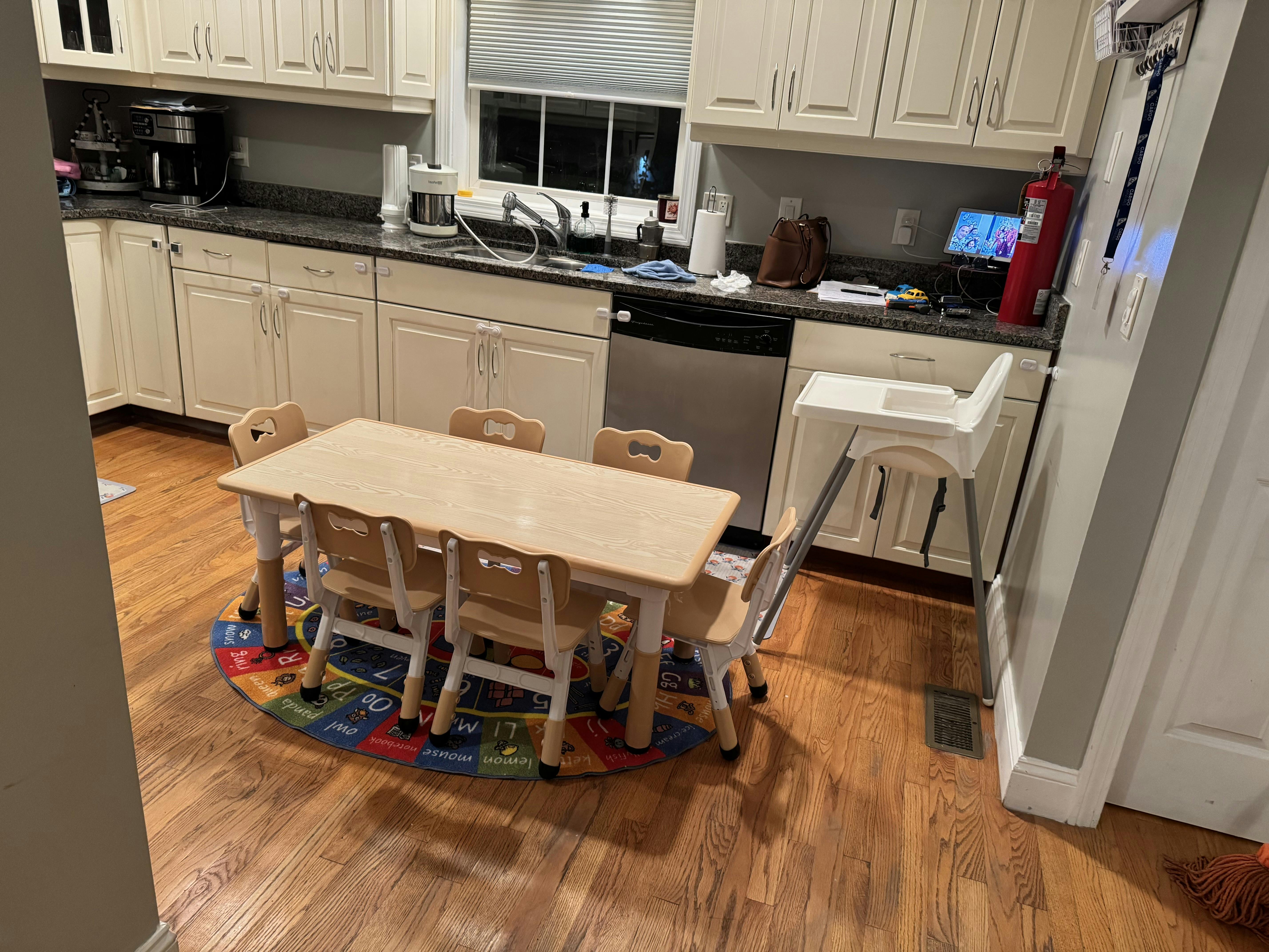 kitchen with child-sized table and chairs on a colorful alphabet rug