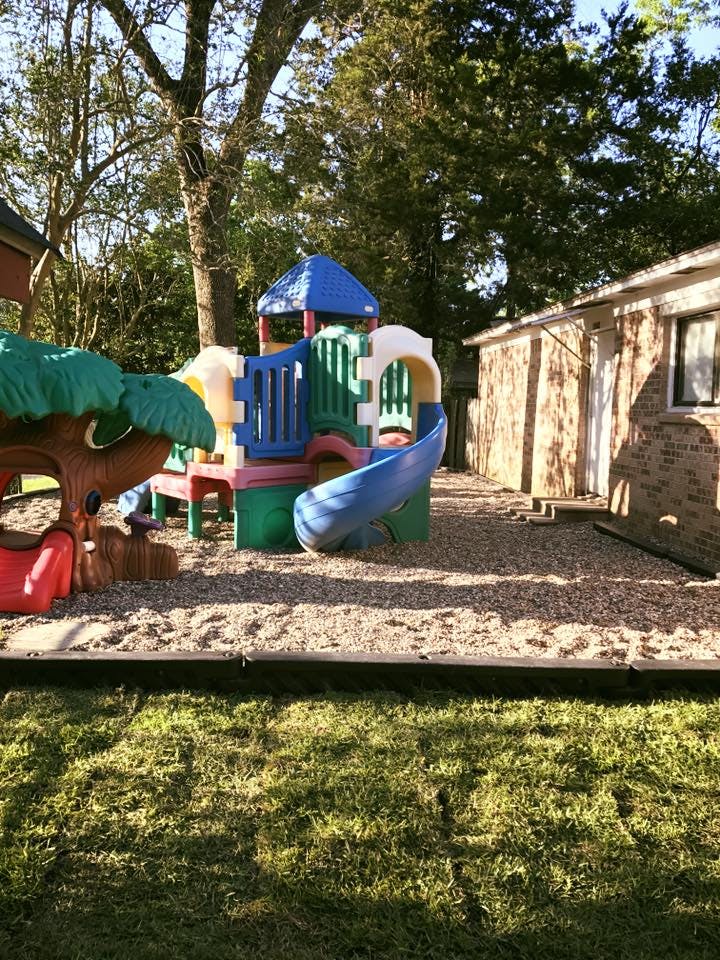 Colorful playground structure with slides and climbing areas on a gravel surface