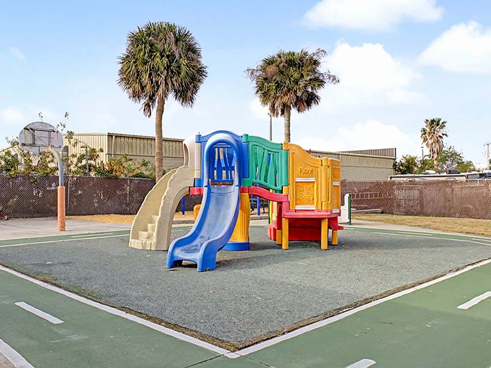 Colorful playground structure with slides and palm trees