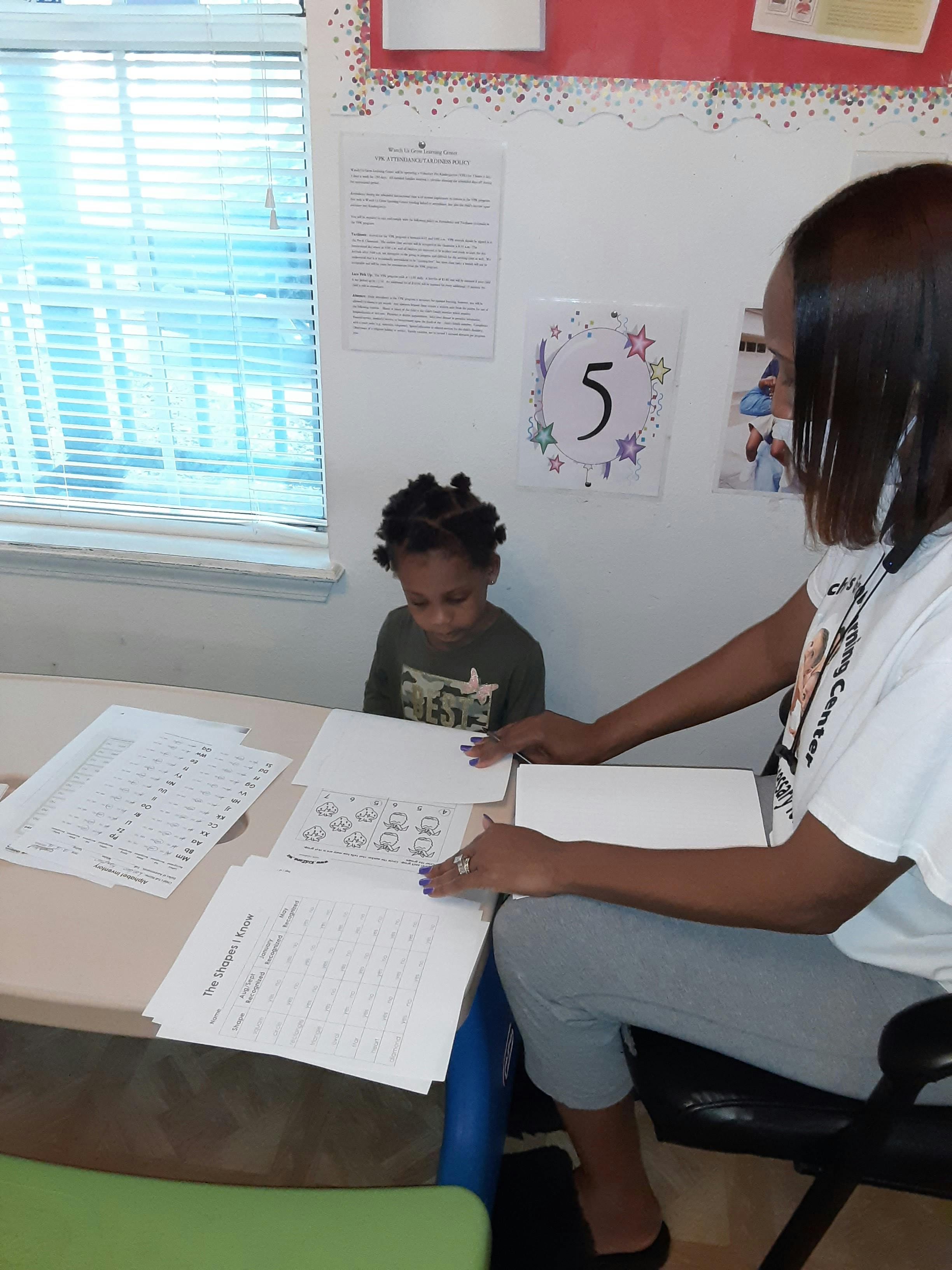 Person and child at a table with papers