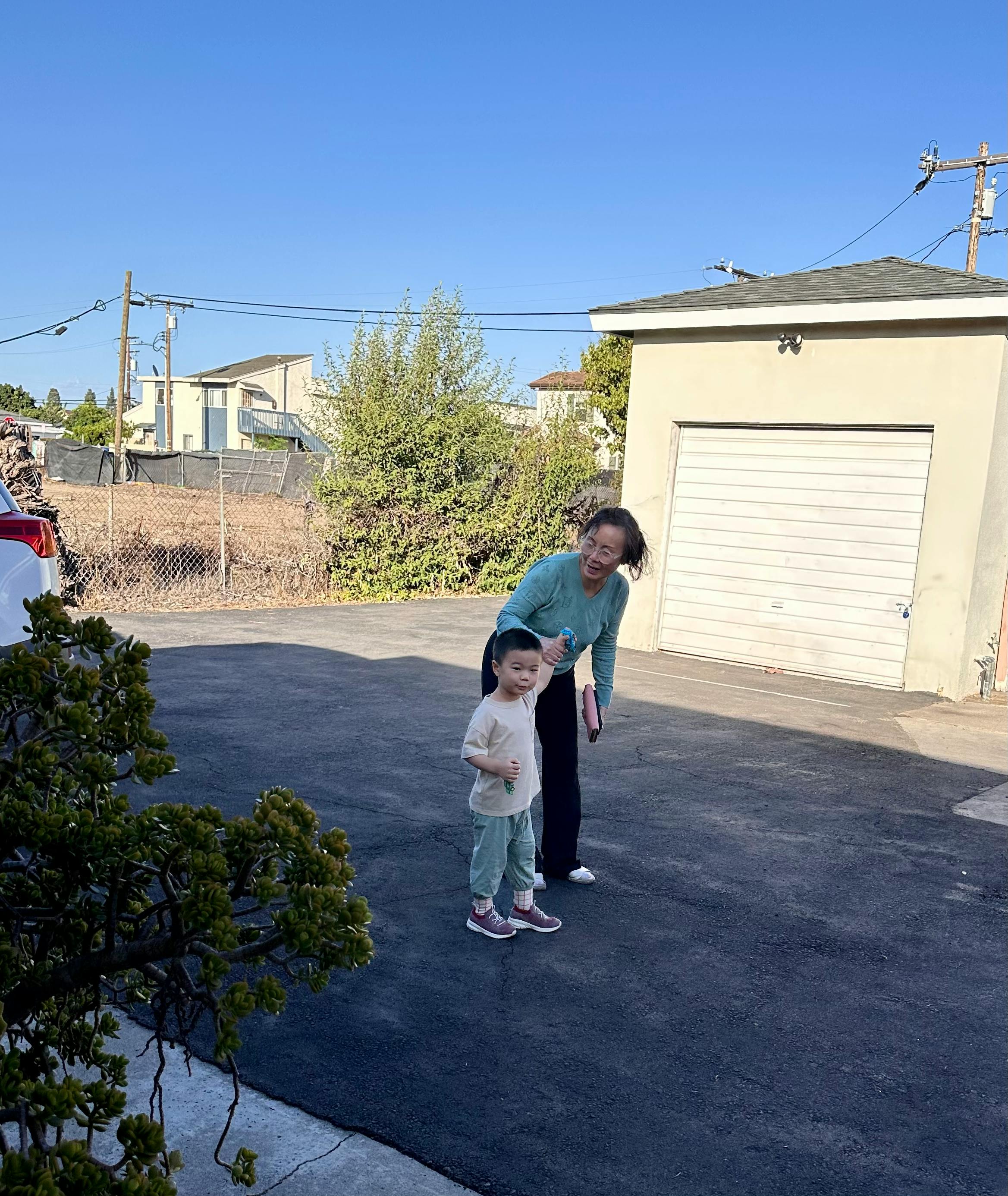 Adult holding hand of a child in a driveway