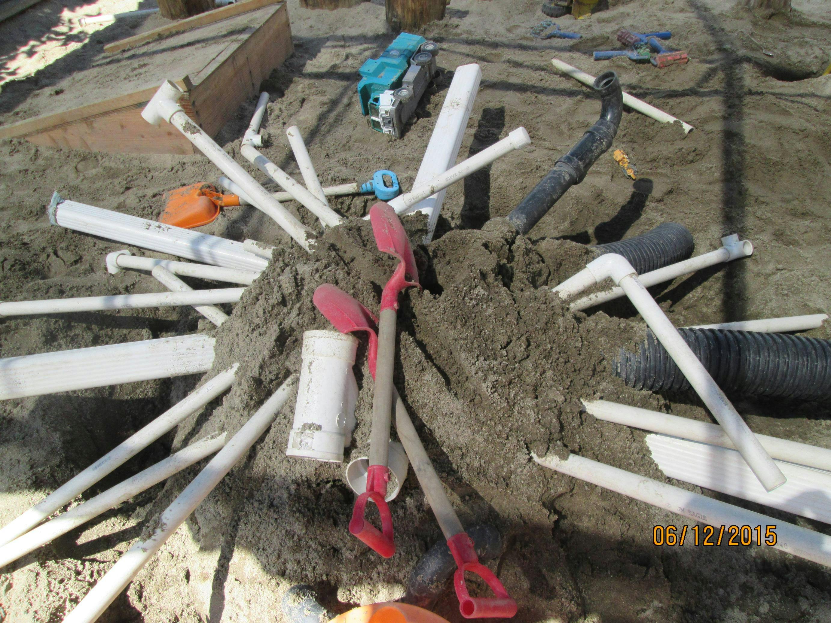 Pipes and tools in a pile of dirt
