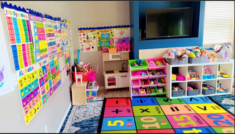 Playroom with colorful educational posters, toy kitchen, and storage shelves