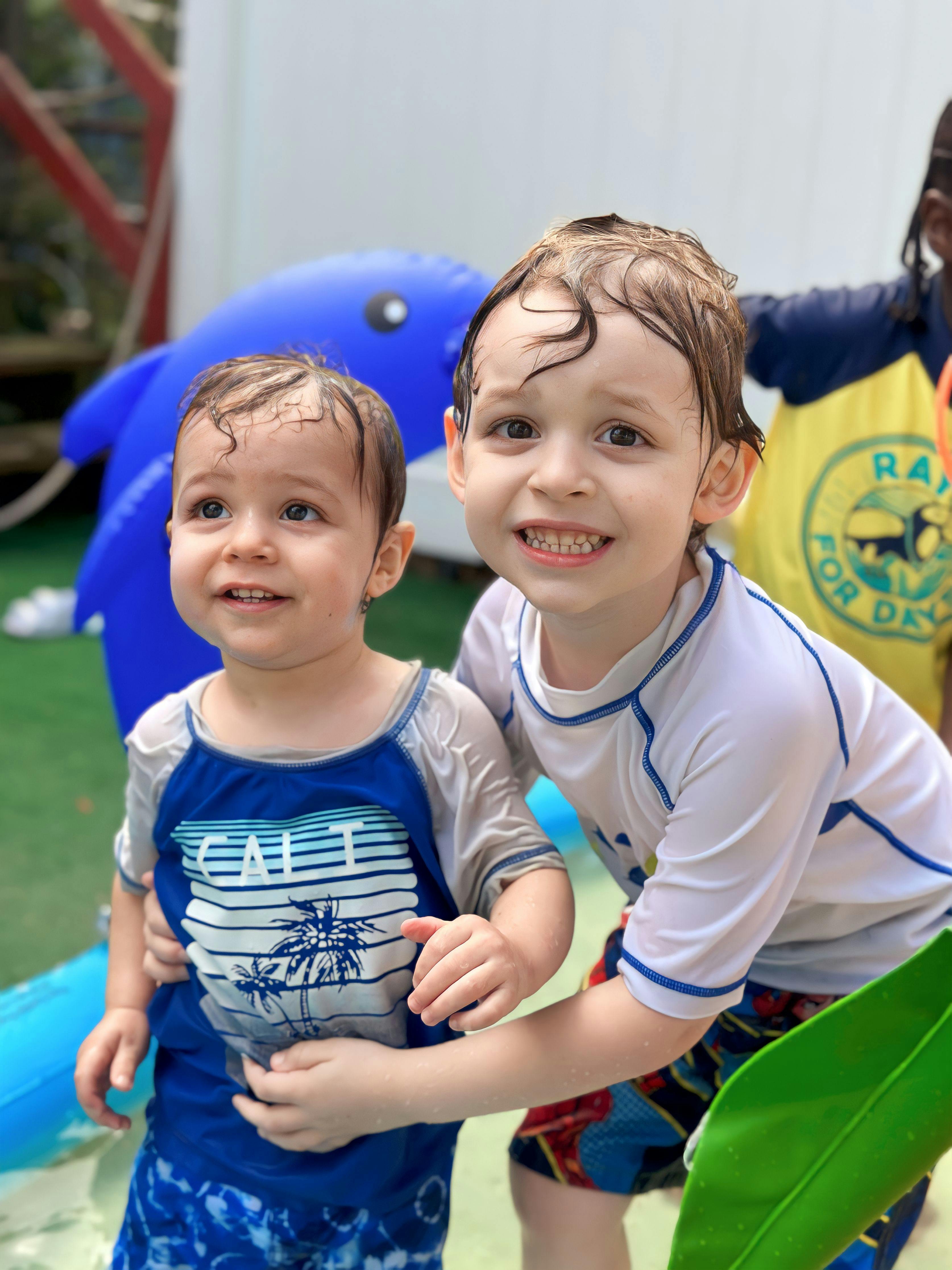 Two children in swimsuits standing in water