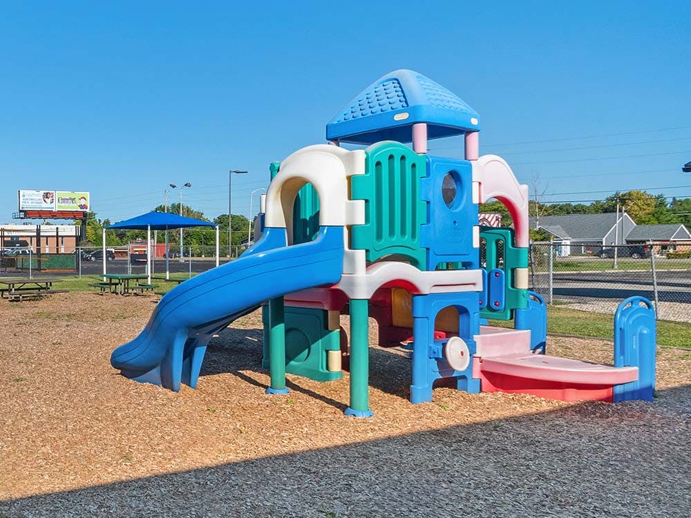 Colorful playground structure with slides on wood chip ground