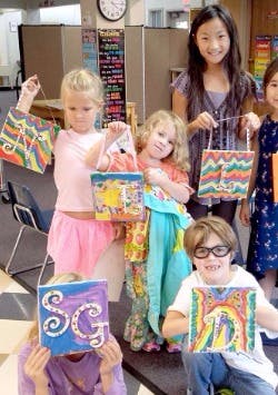 Children holding up art projects