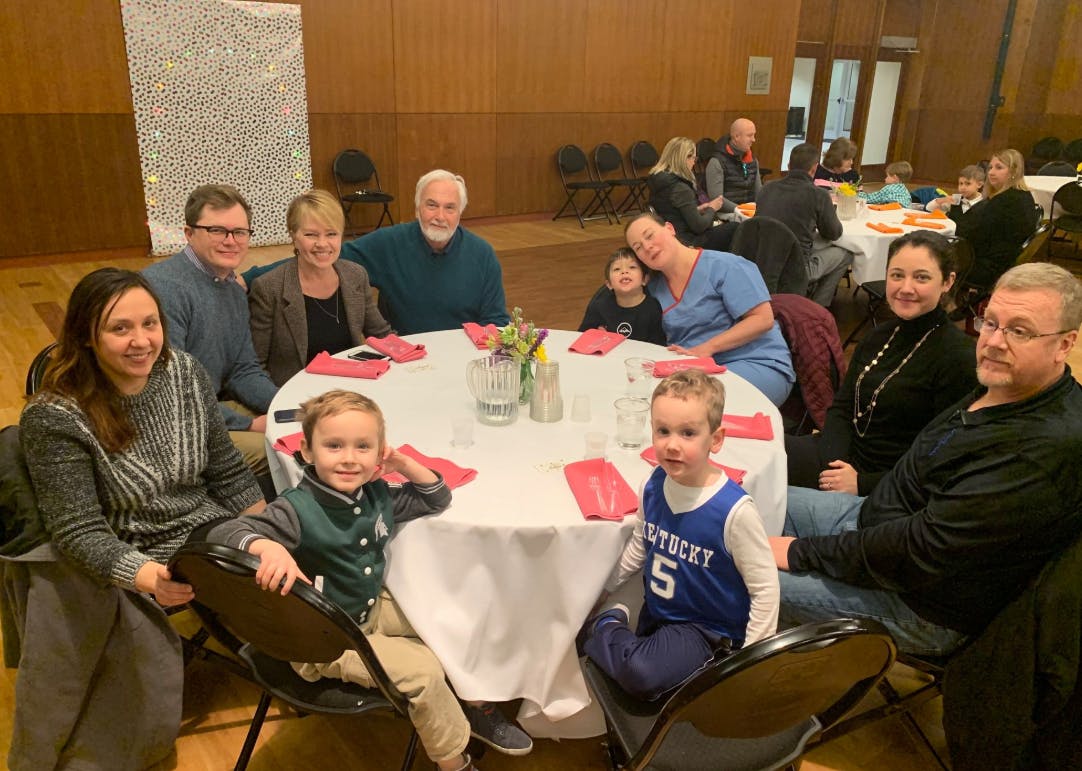 Group of people and children sitting around a table