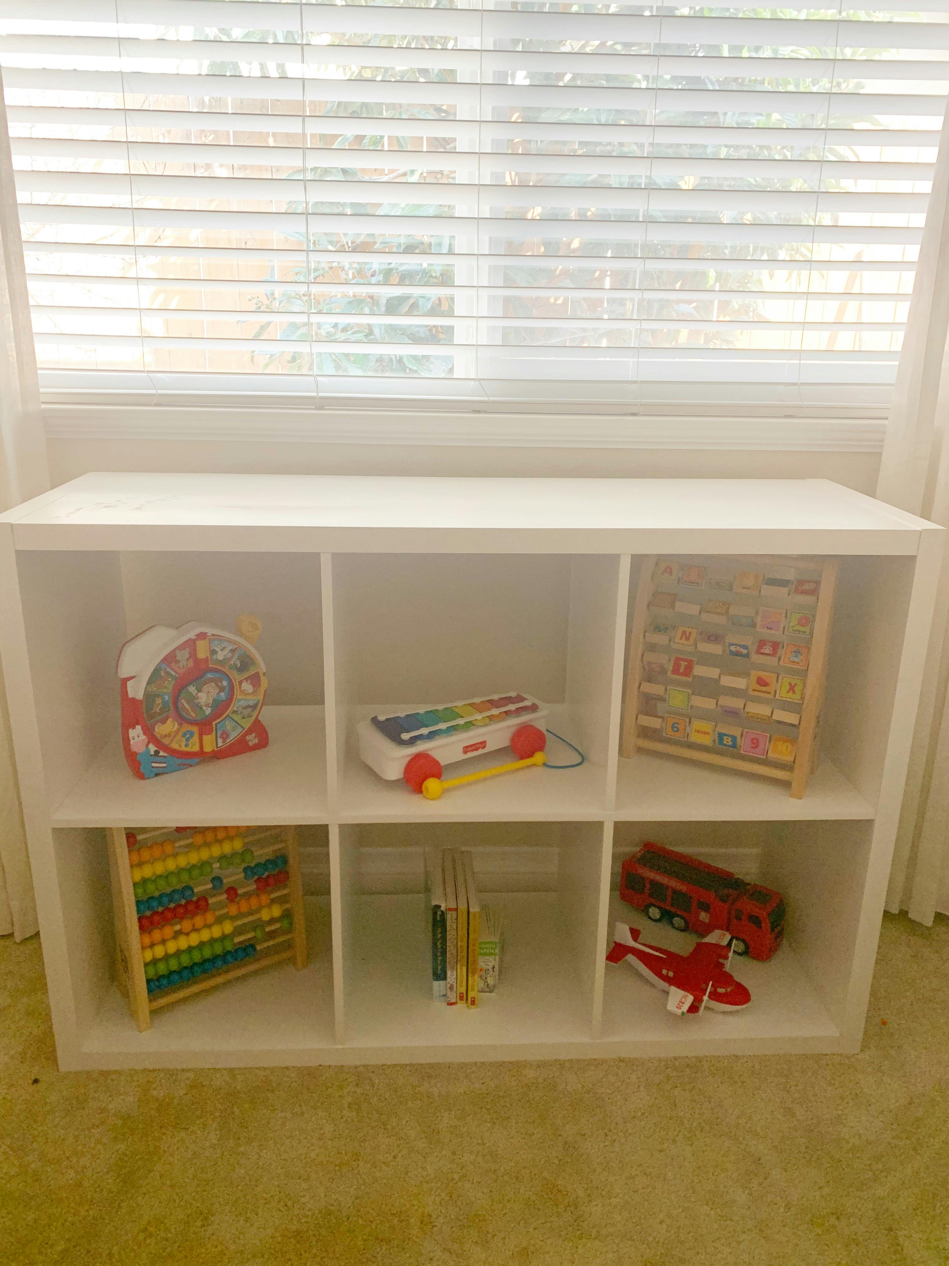White cubby shelf with various toys and books