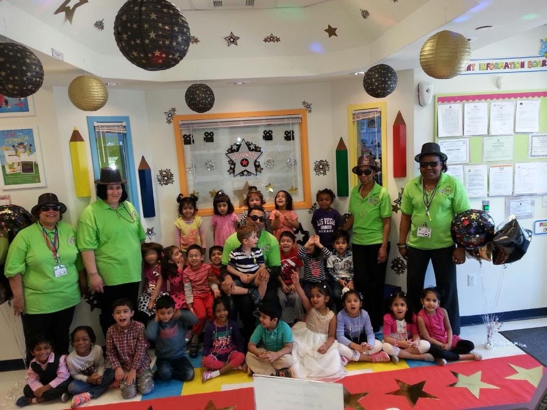 Adults and children posing in a classroom