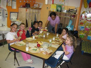 Adult and children at a table in a classroom