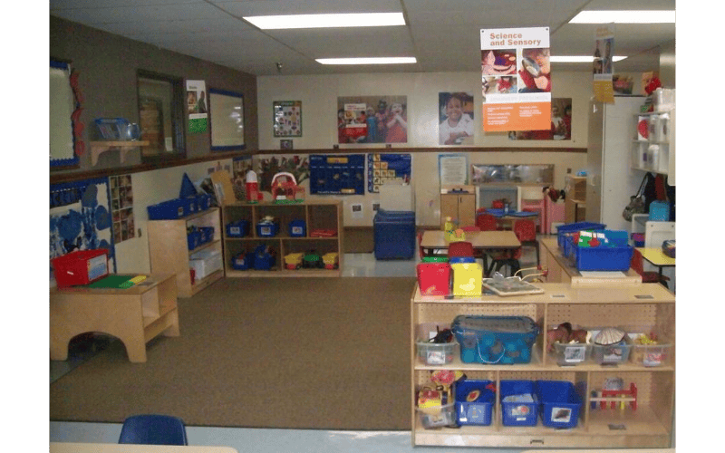 Empty classroom with shelves of toys and small tables