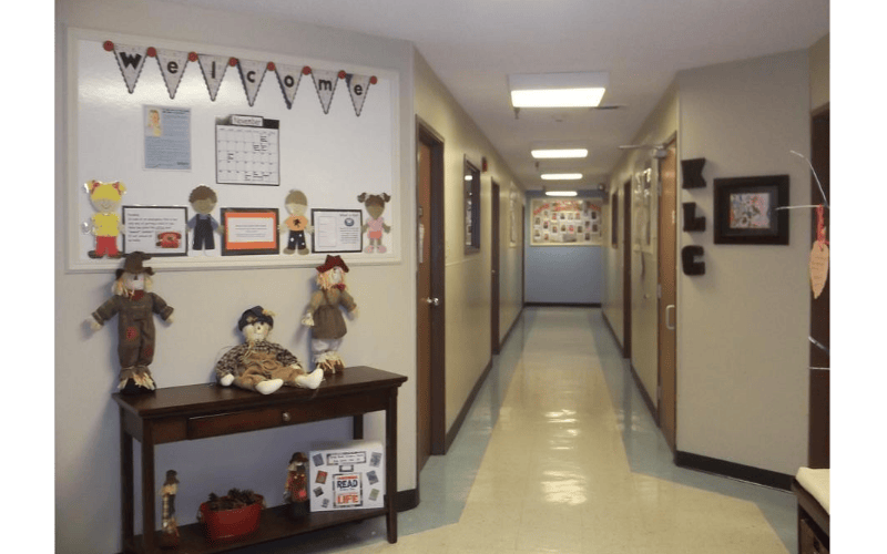 Hallway decorated with a WELCOME banner and scarecrow dolls