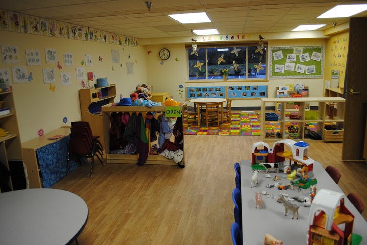 Empty classroom with tables, chairs, and toys