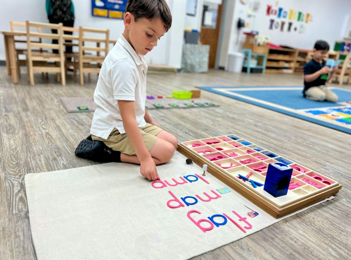 Child on floor assembling words with alphabet letters
