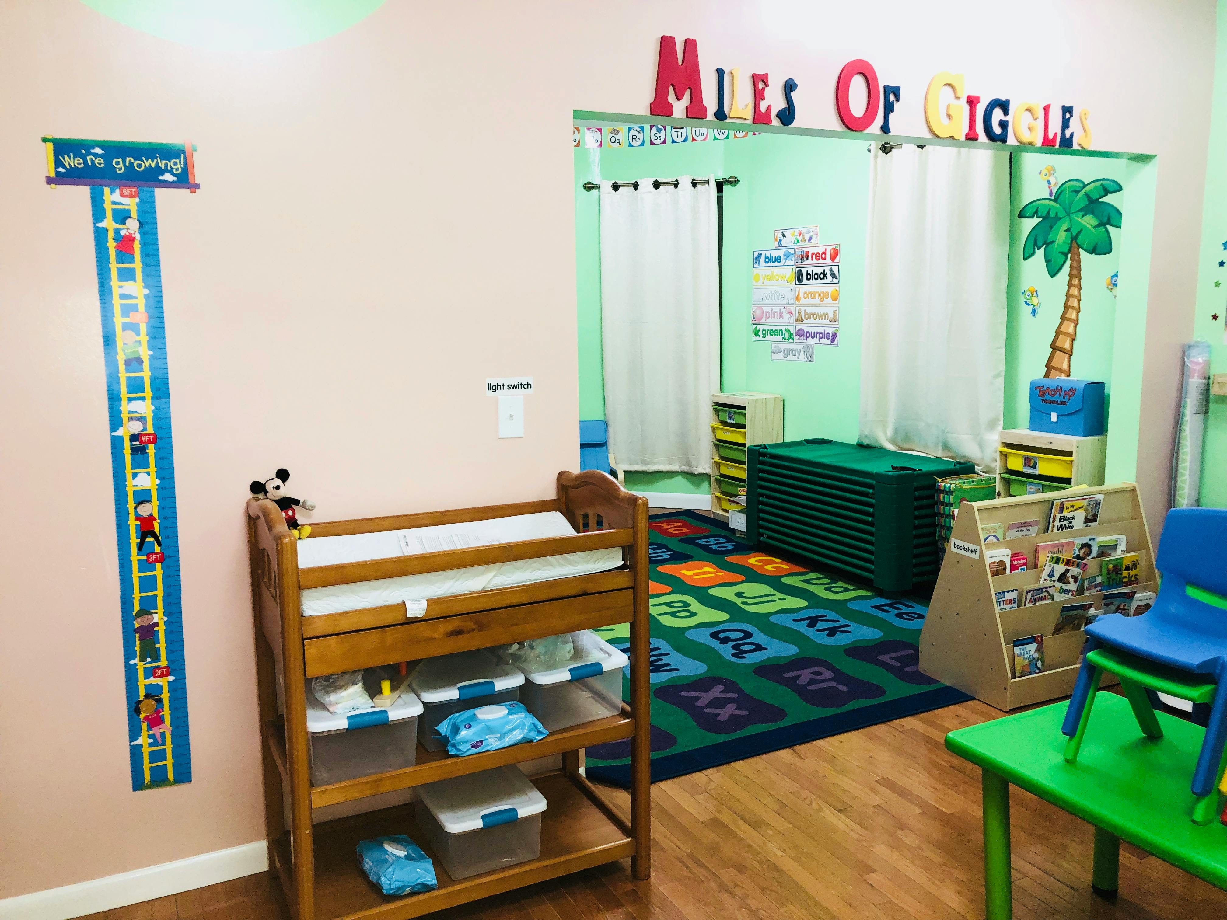 Changing table in a classroom with a colorful rug and play area