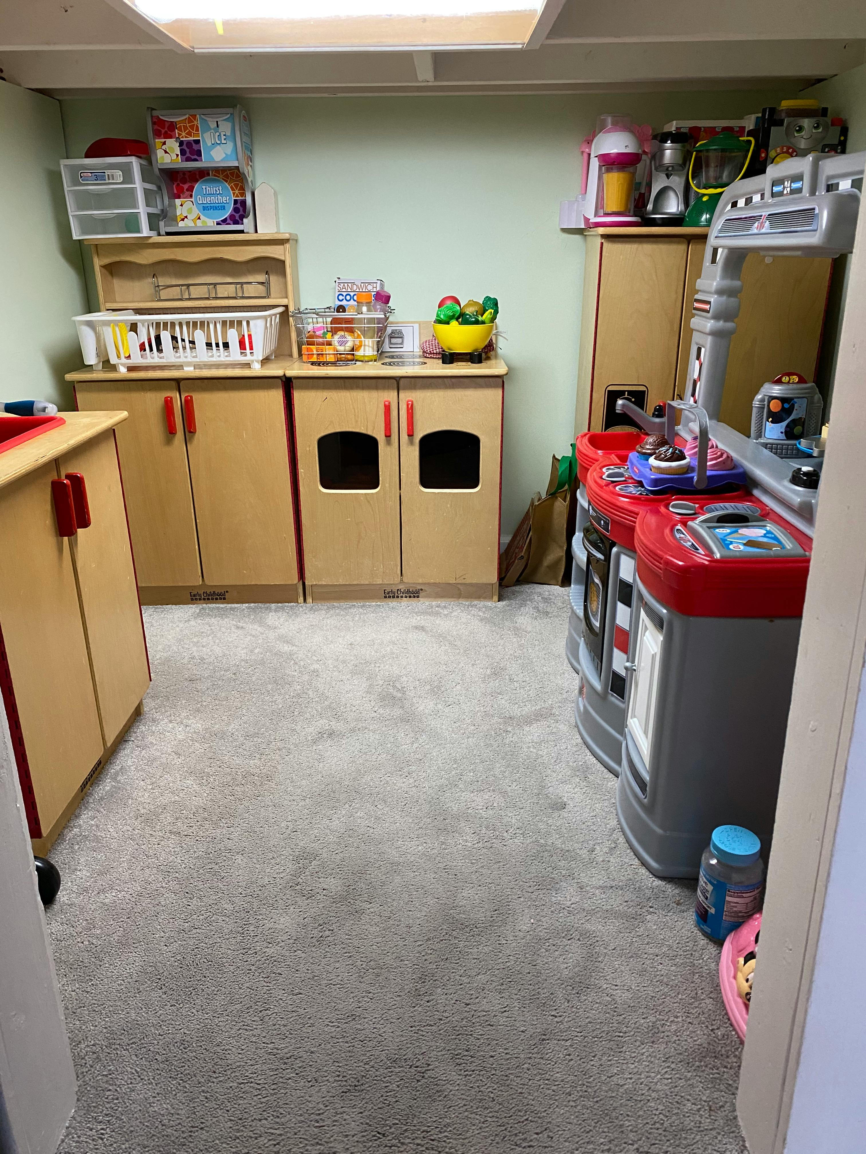 Playroom with toy kitchen and wooden storage cabinets
