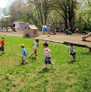 Children running on a grassy playground