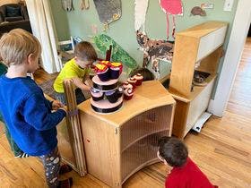 Three children playing with toys in a room