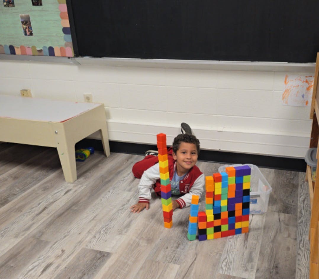 Child on floor with colorful building blocks
