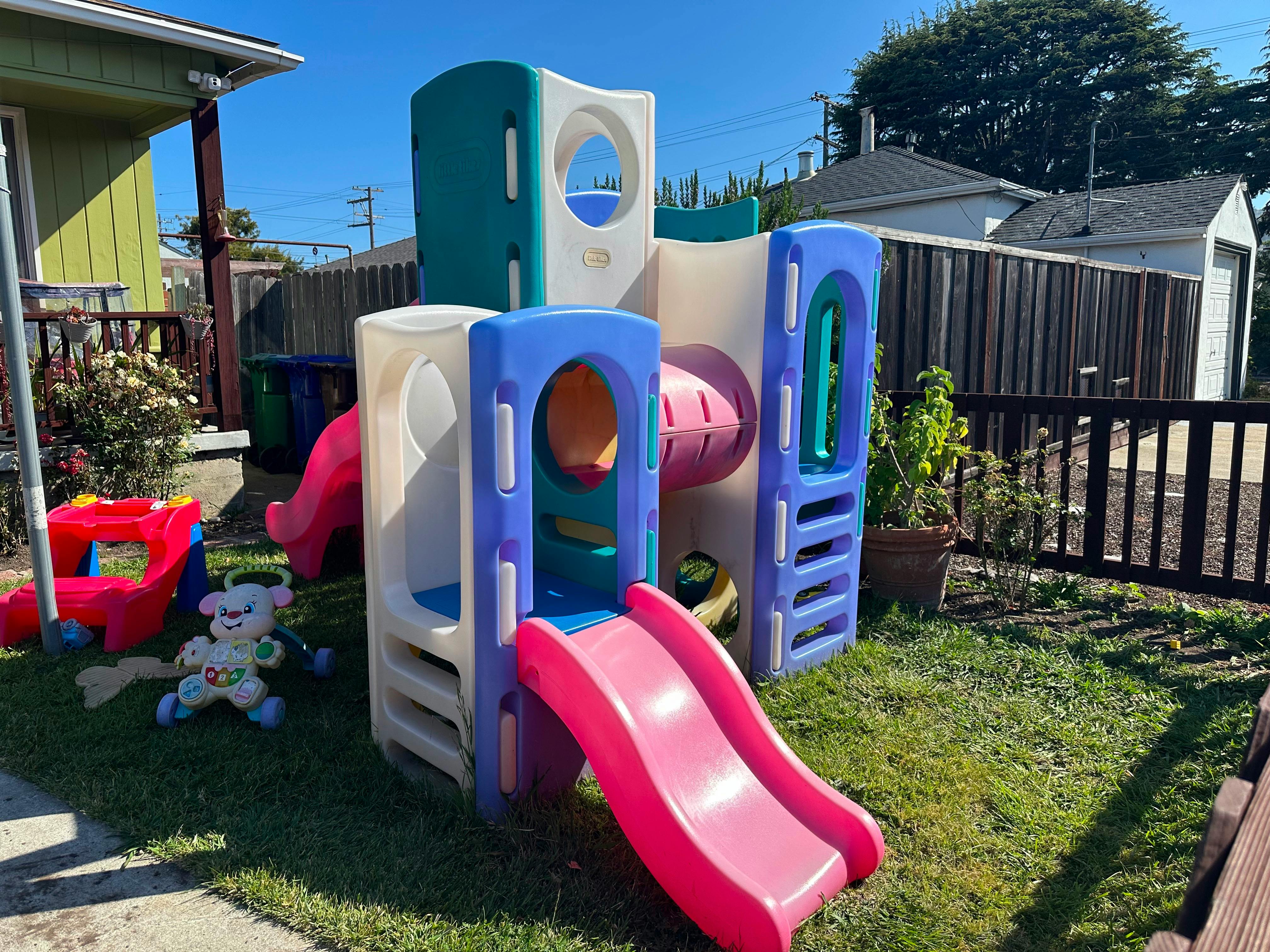 Plastic playground climber with slides in a backyard