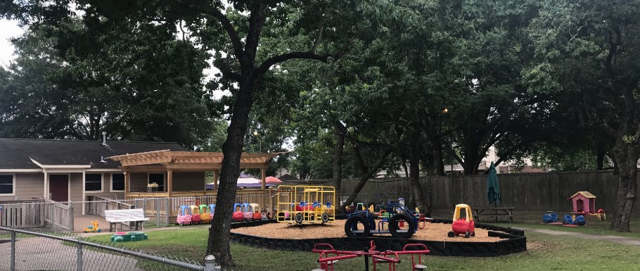 Outdoor playground with swings, slides, and a small building