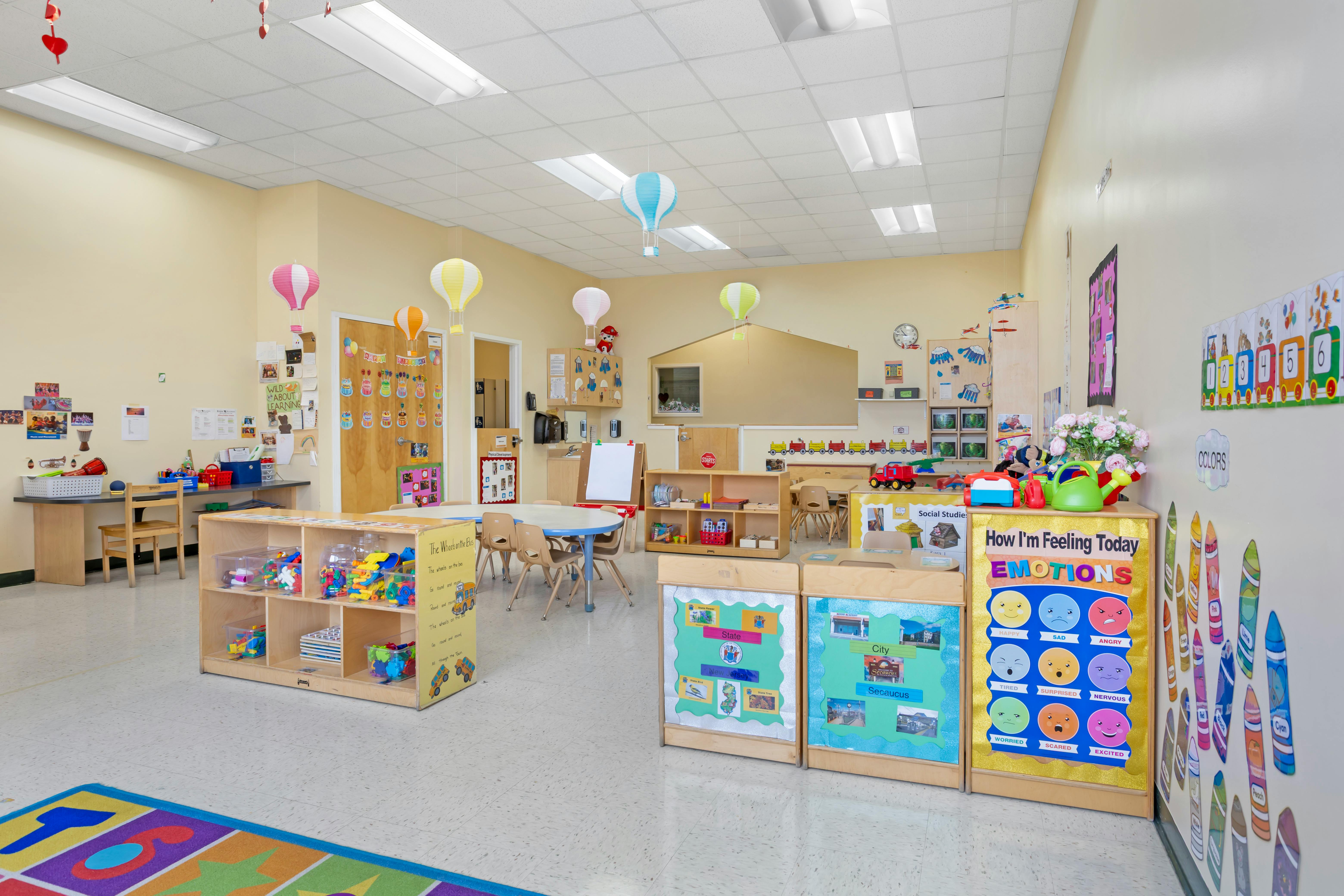 Classroom with tables, chairs, shelves, and colorful decorations