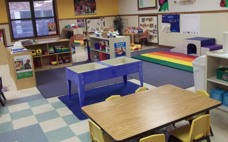 Classroom with multiple activity areas and small child-sized furniture