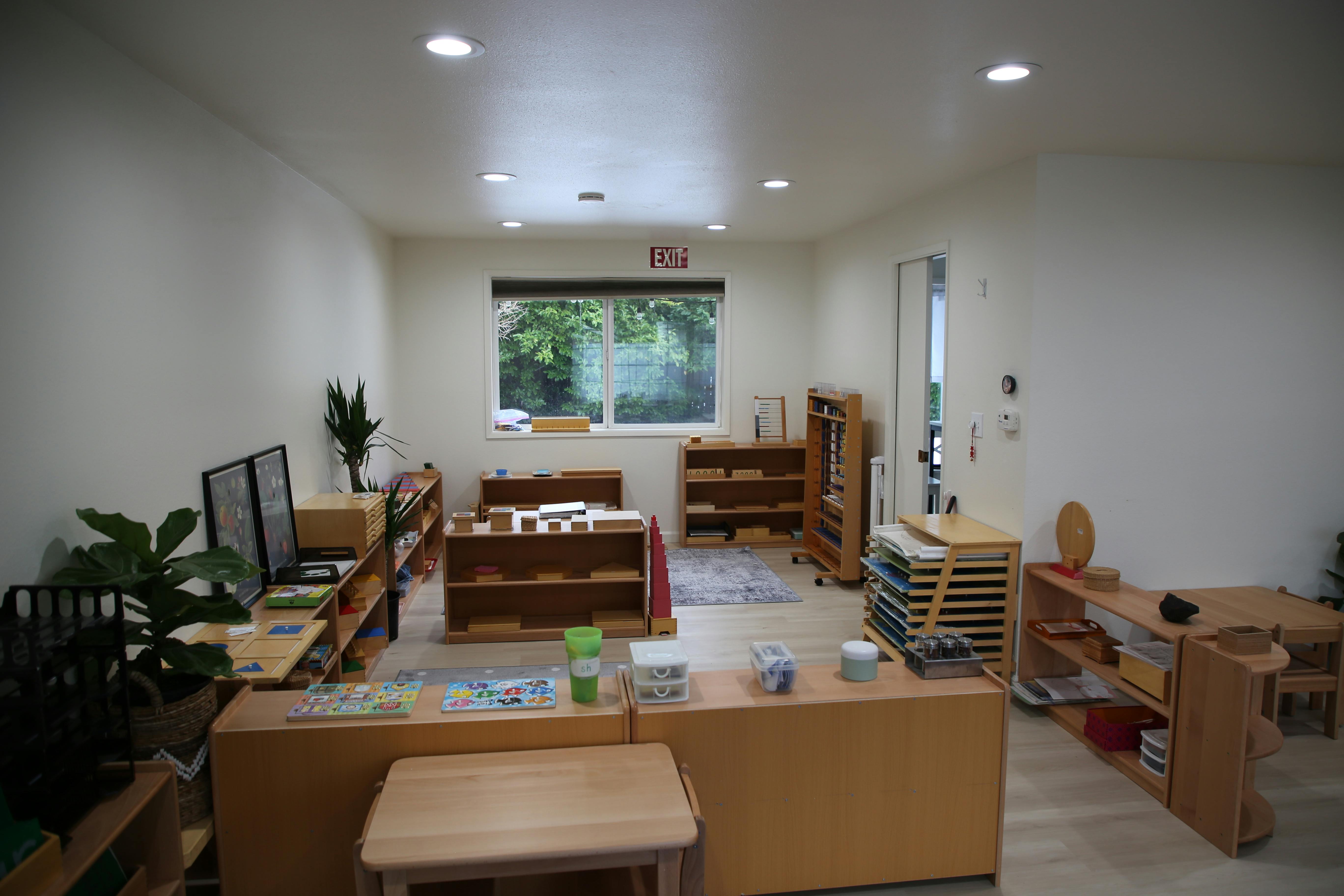 Classroom with wooden shelves, tables, and learning materials