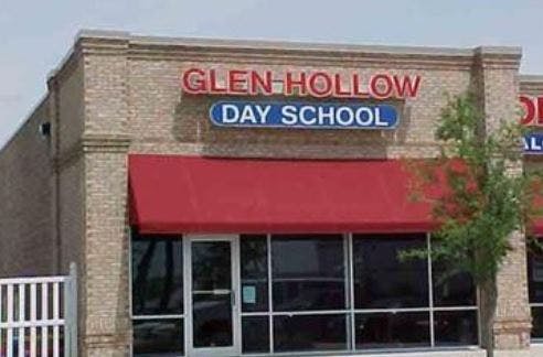 Glen Hollow Day School sign on a brick building with a red awning