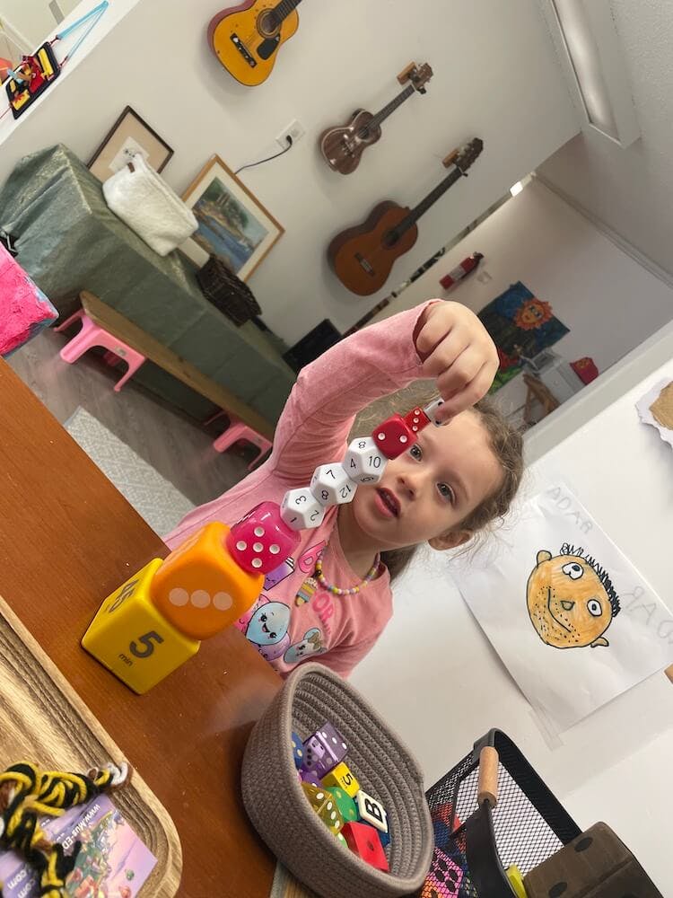 Child playing with a stack of colorful dice