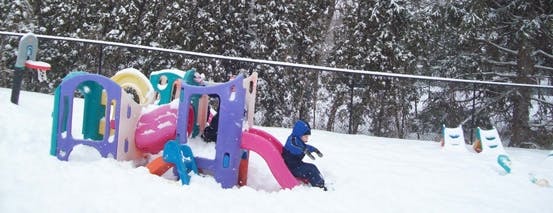 Child on a playground slide in the snow