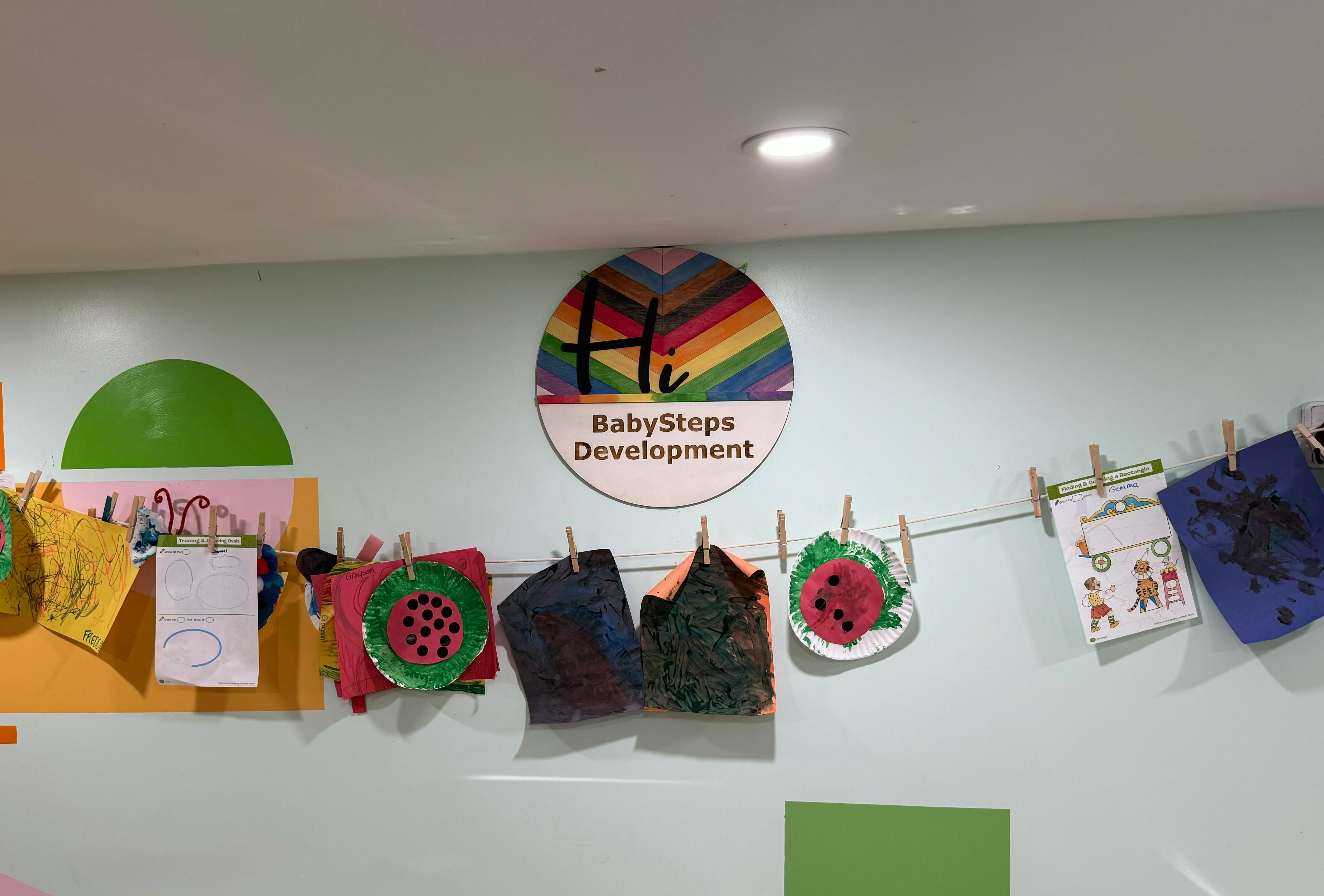 Children's artwork displayed on a string with clothespins