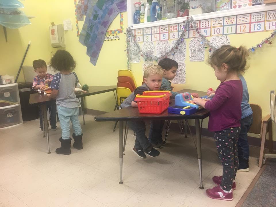 Children playing at tables in a classroom