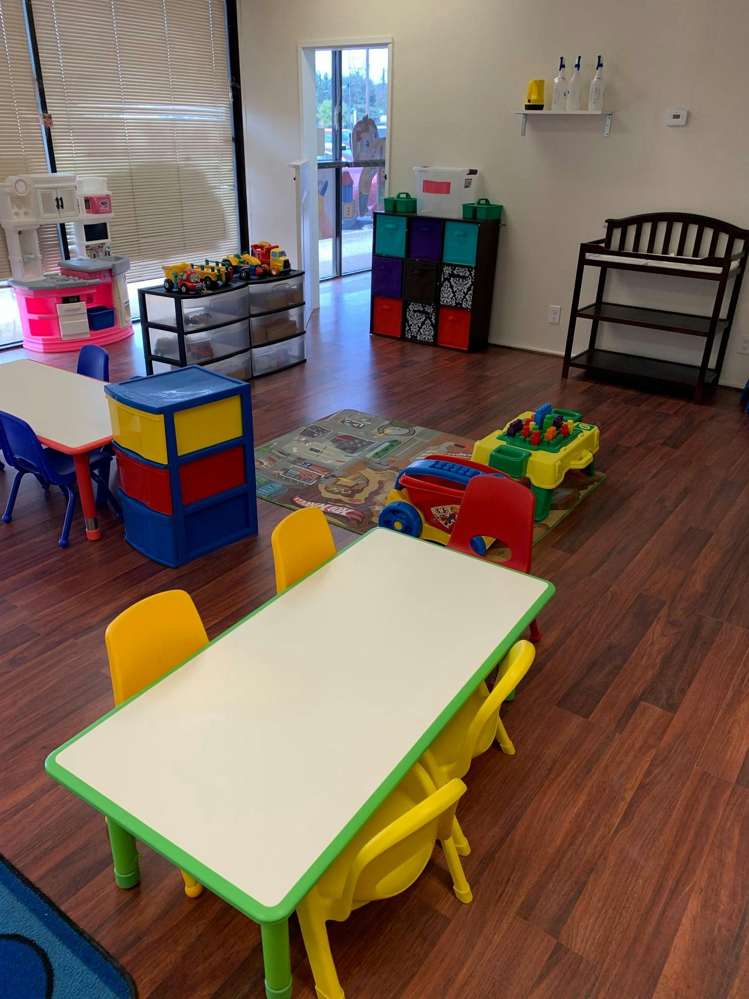 Playroom with small tables and chairs, toys, and storage units