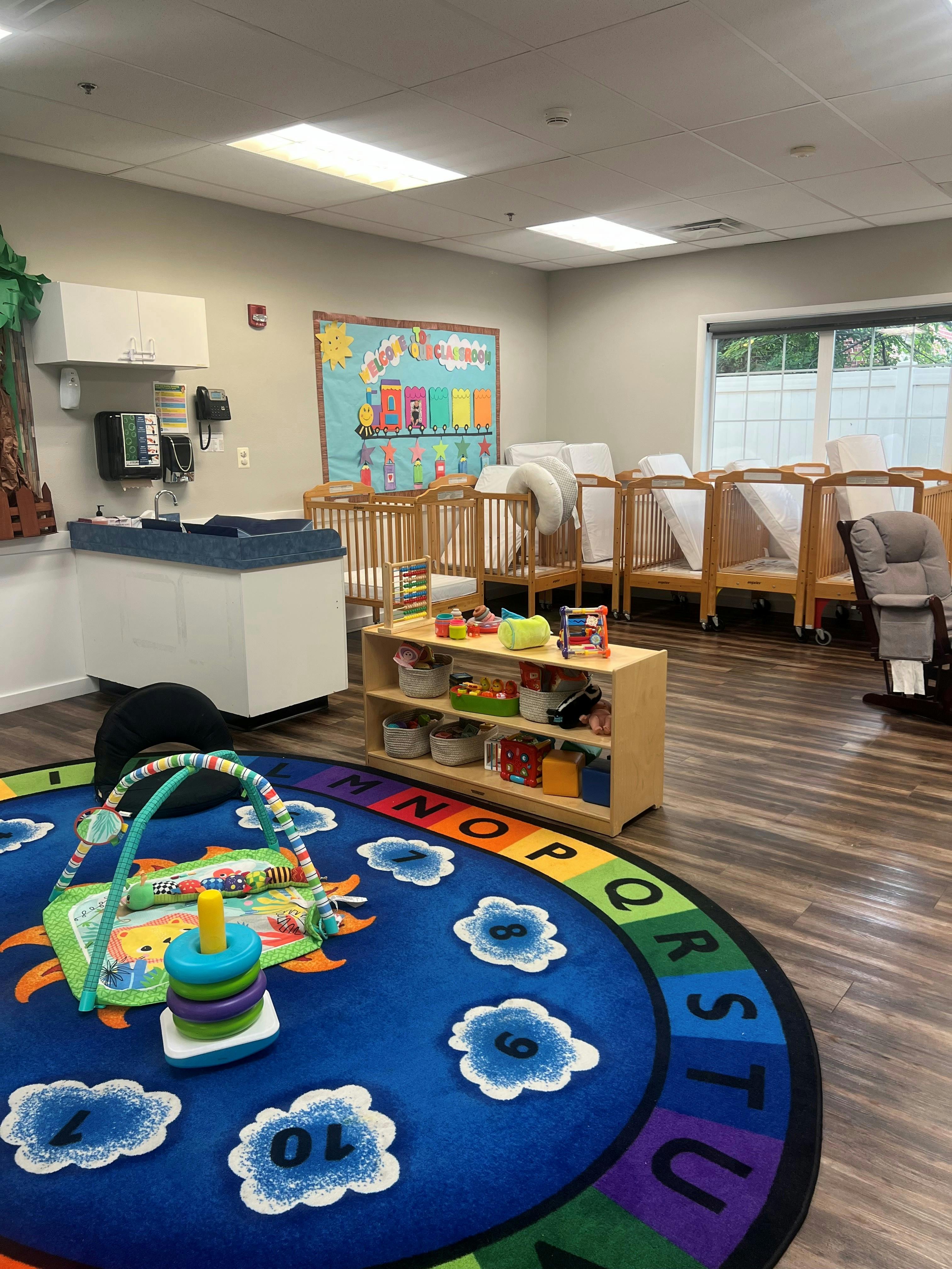 Childcare classroom with play mats and wooden cribs