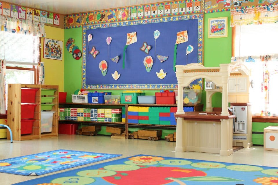 Colorful classroom with play area, shelves, and bulletin board