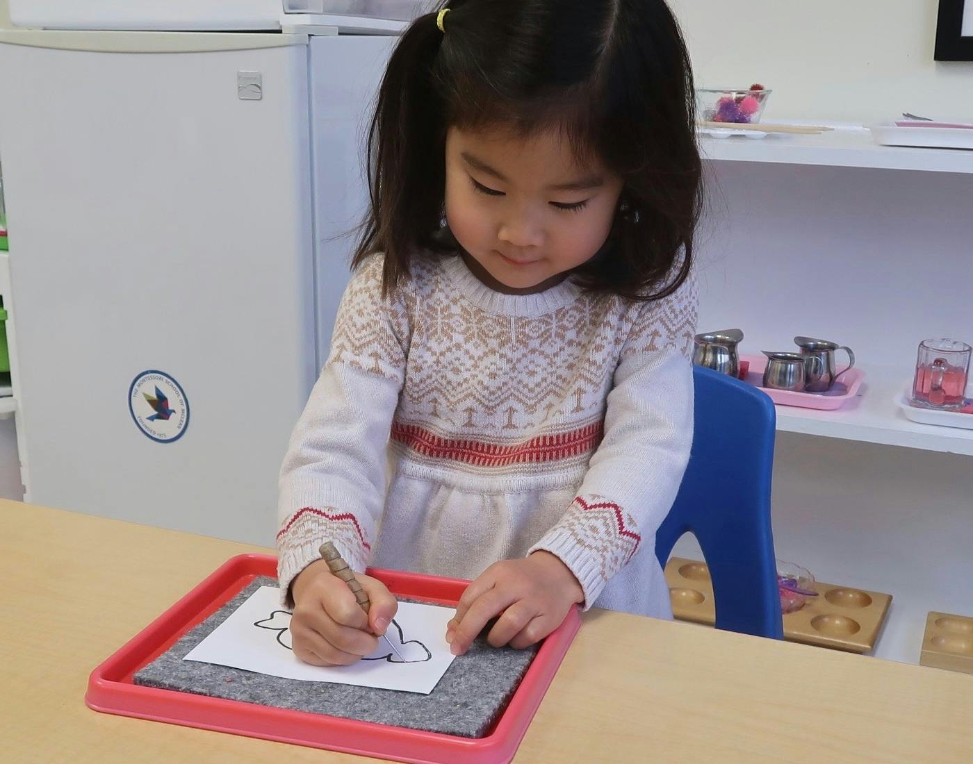 Child drawing on paper with a pencil