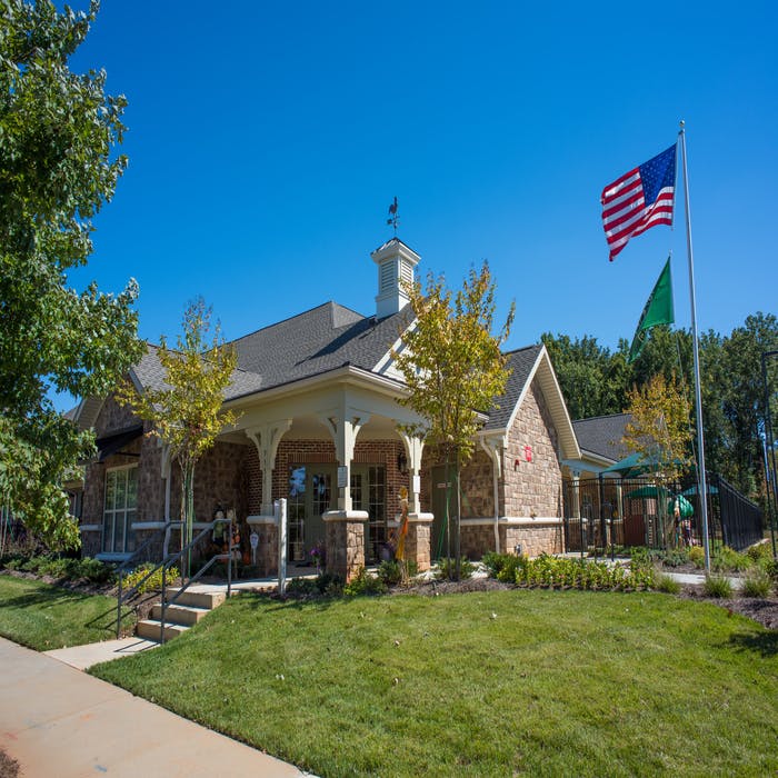 Building with a porch, cupola, and an American flag flying