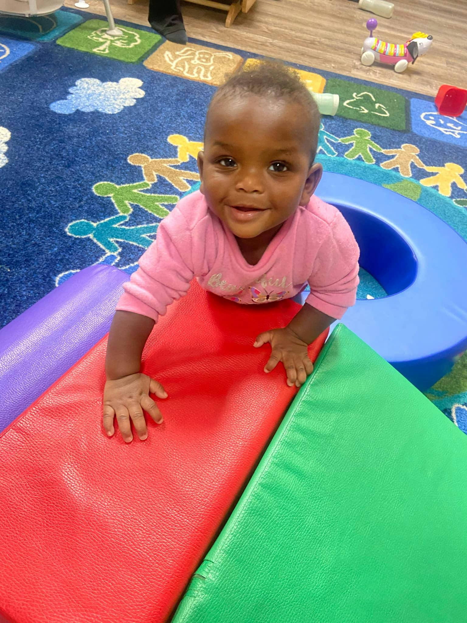 Smiling child on colorful soft play equipment