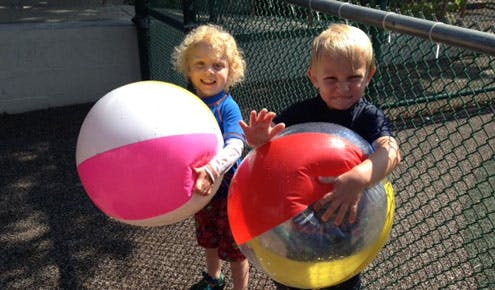 Two children holding beach balls