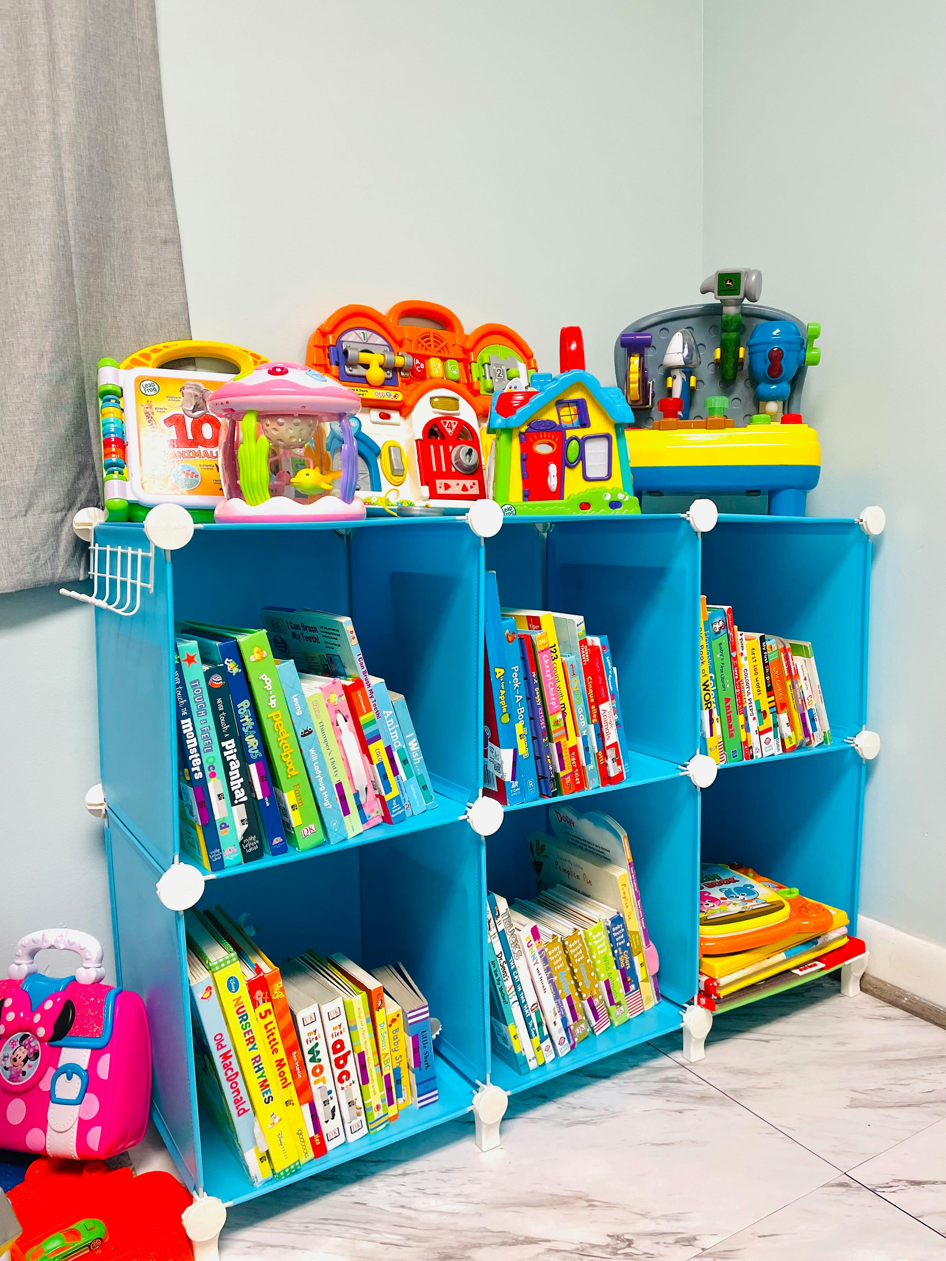 Blue modular shelving unit with books and toys
