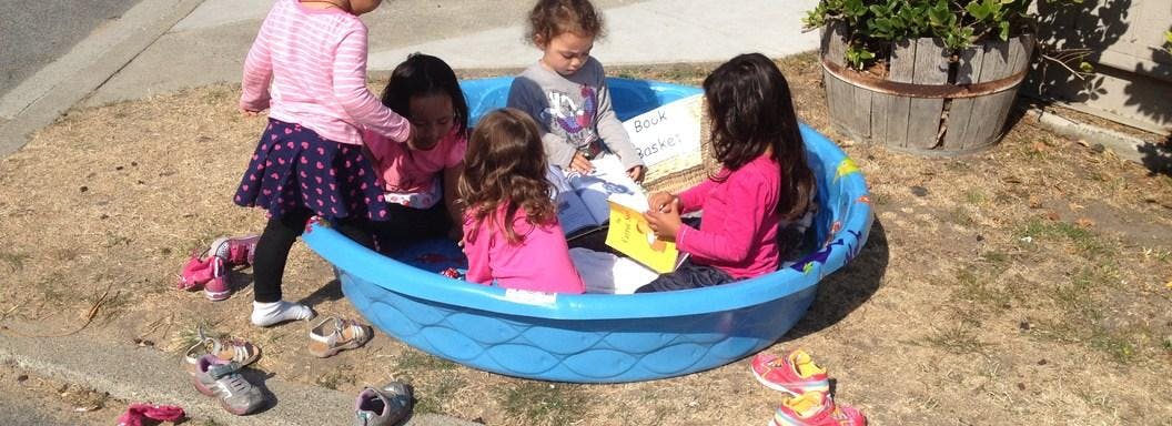 Children playing in a blue plastic pool