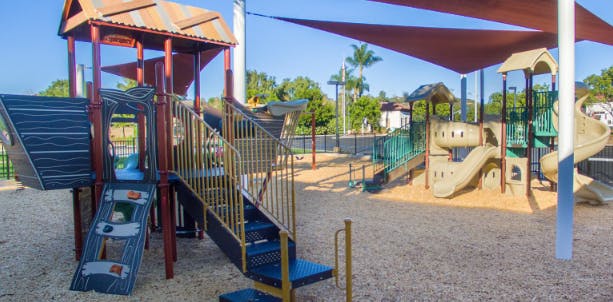 Empty playground with slides, climbing structures, and shade sails